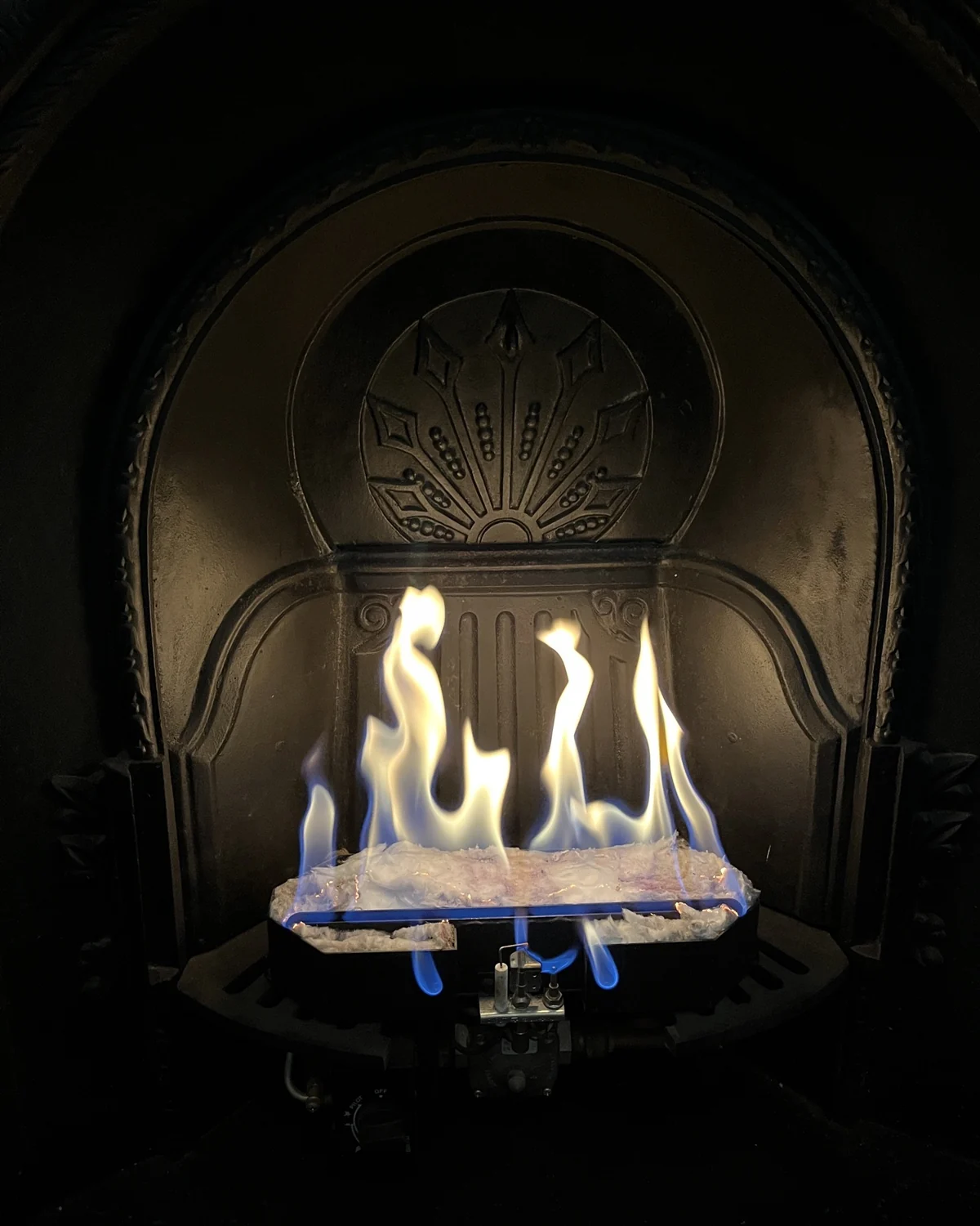 Lit gas fireplace checked after a Peach Plumbing service