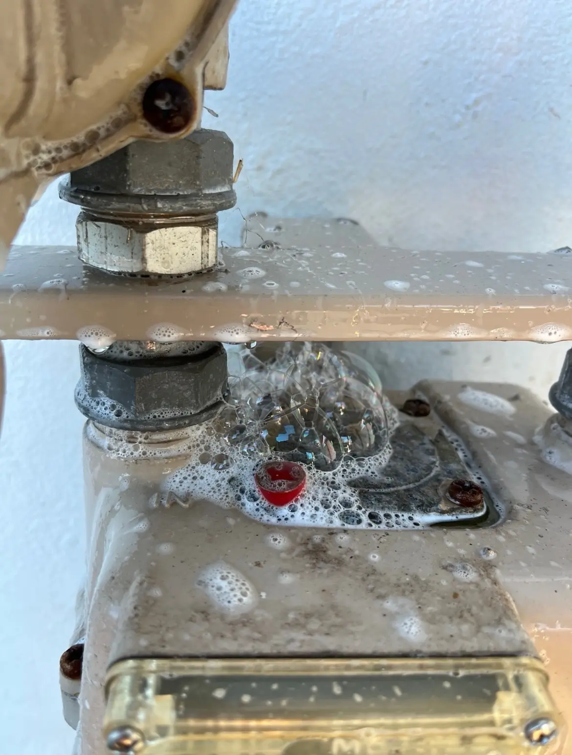 Gas fitting checked with leak-detection solution
