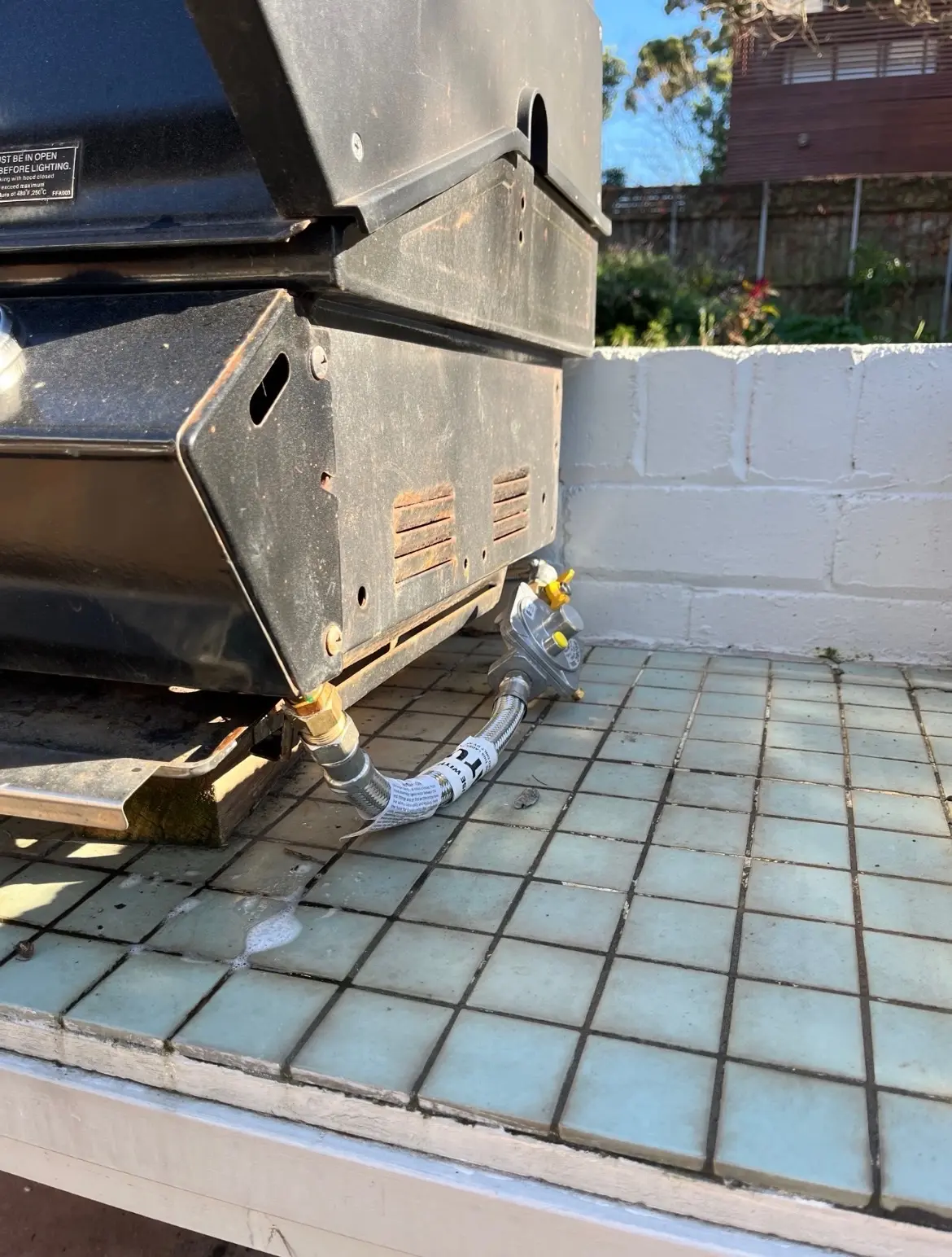 Natural-gas hose and regulator at an outdoor barbecue connection