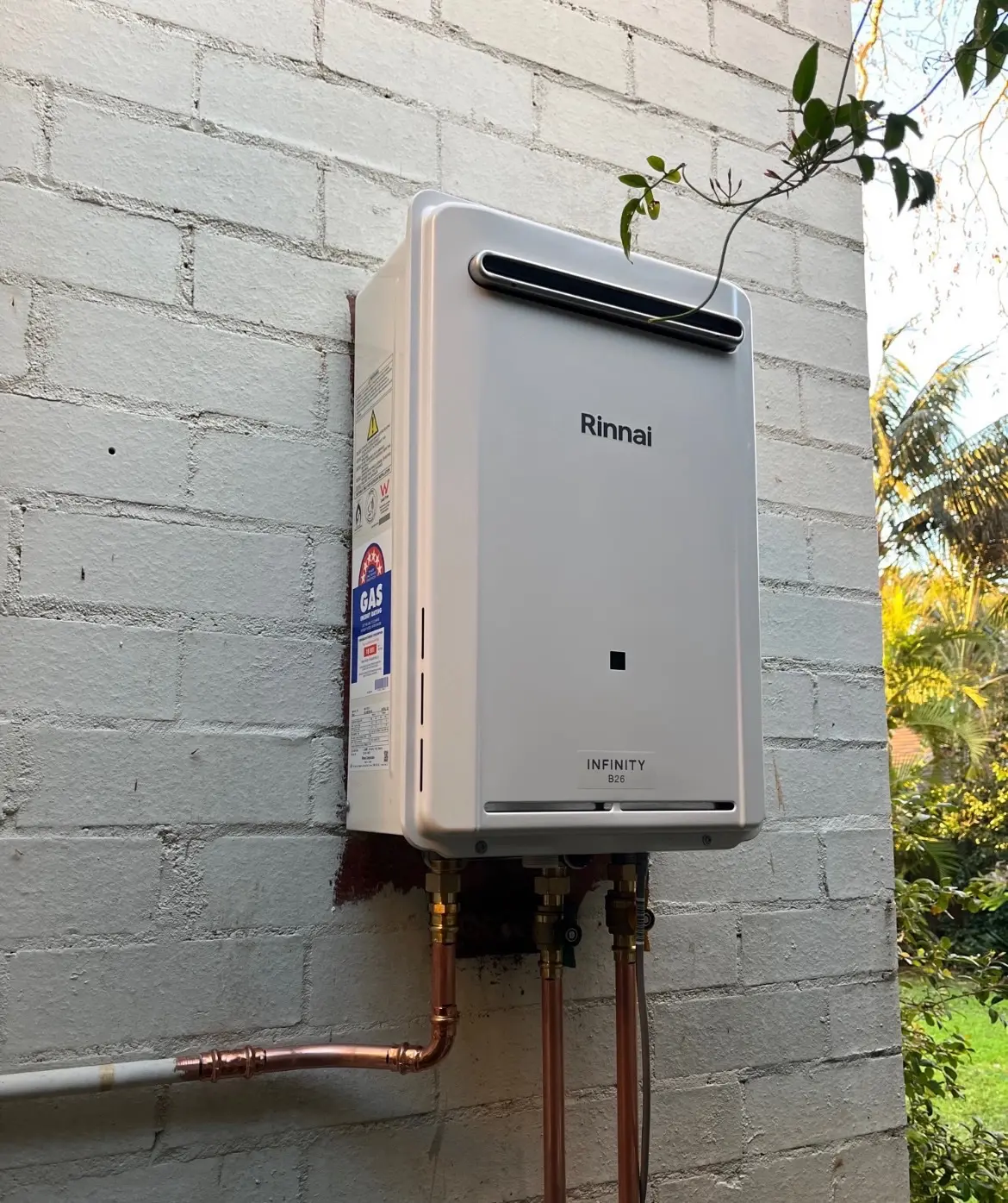 Continuous-flow hot water system fitted to an exterior wall