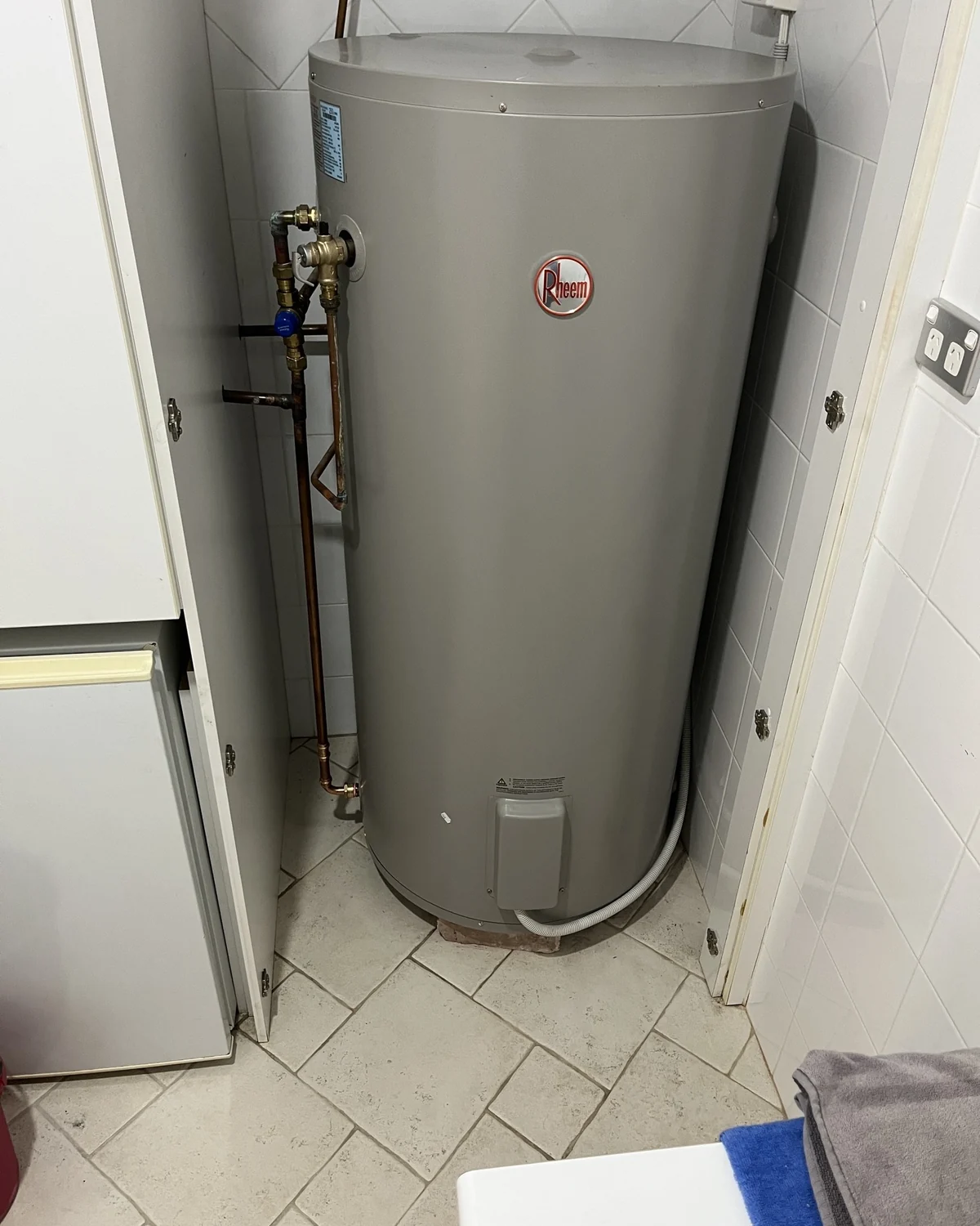 Completed storage hot-water system installation in a cupboard