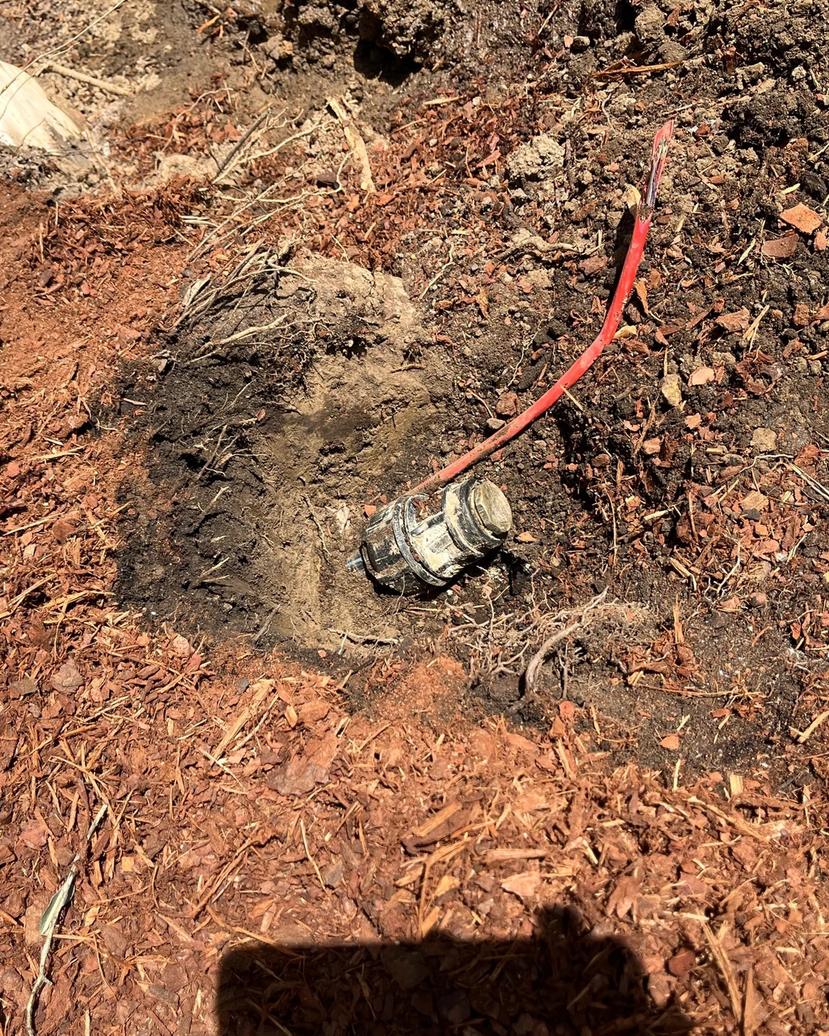 Exposed damaged garden water line prepared for repair