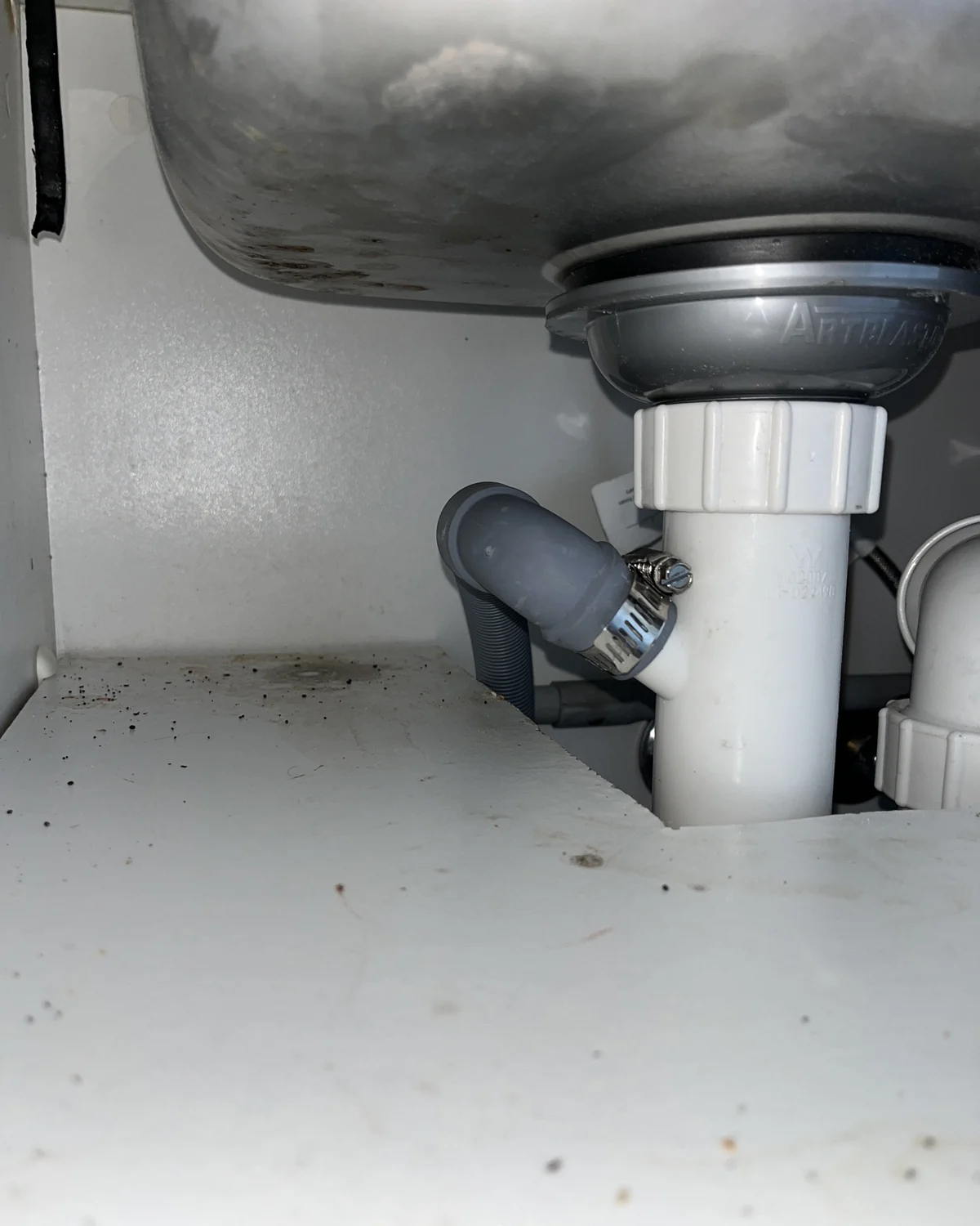Dishwasher outlet hose connection below a kitchen sink
